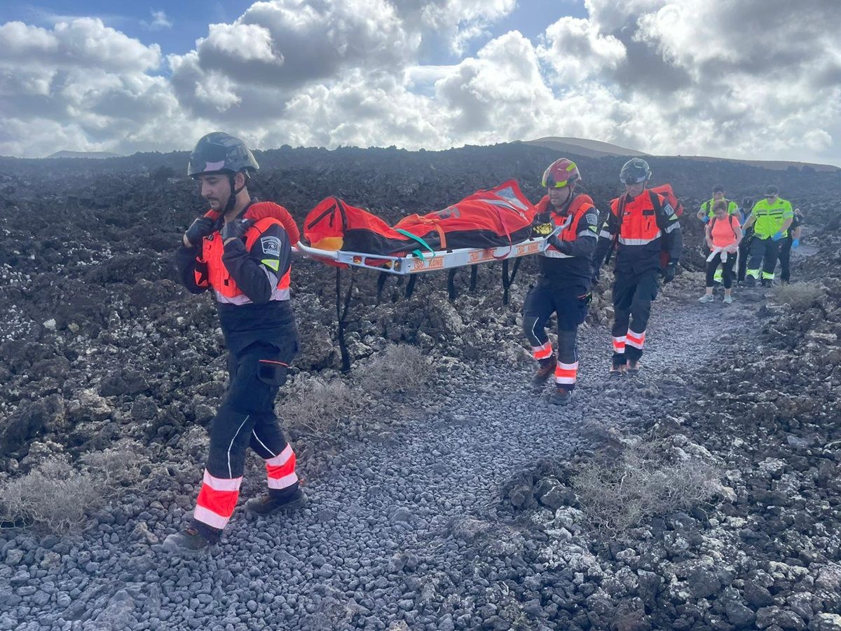 Los bomberos trasladando a la mujer en camilla en Caldera Blanca