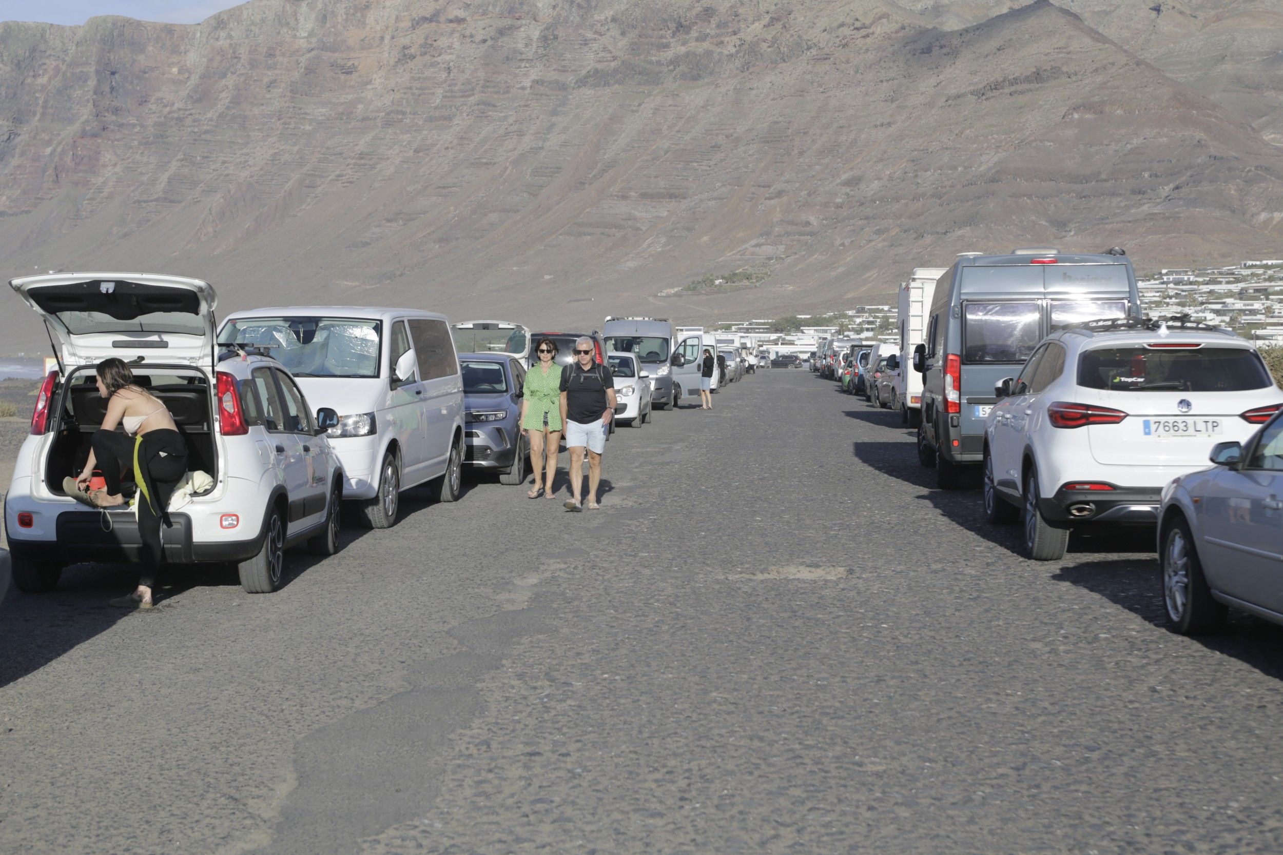 Vehículos aparcados en la carretera entre los bungalows y la playa de Famara. Foto: Juan Mateos.