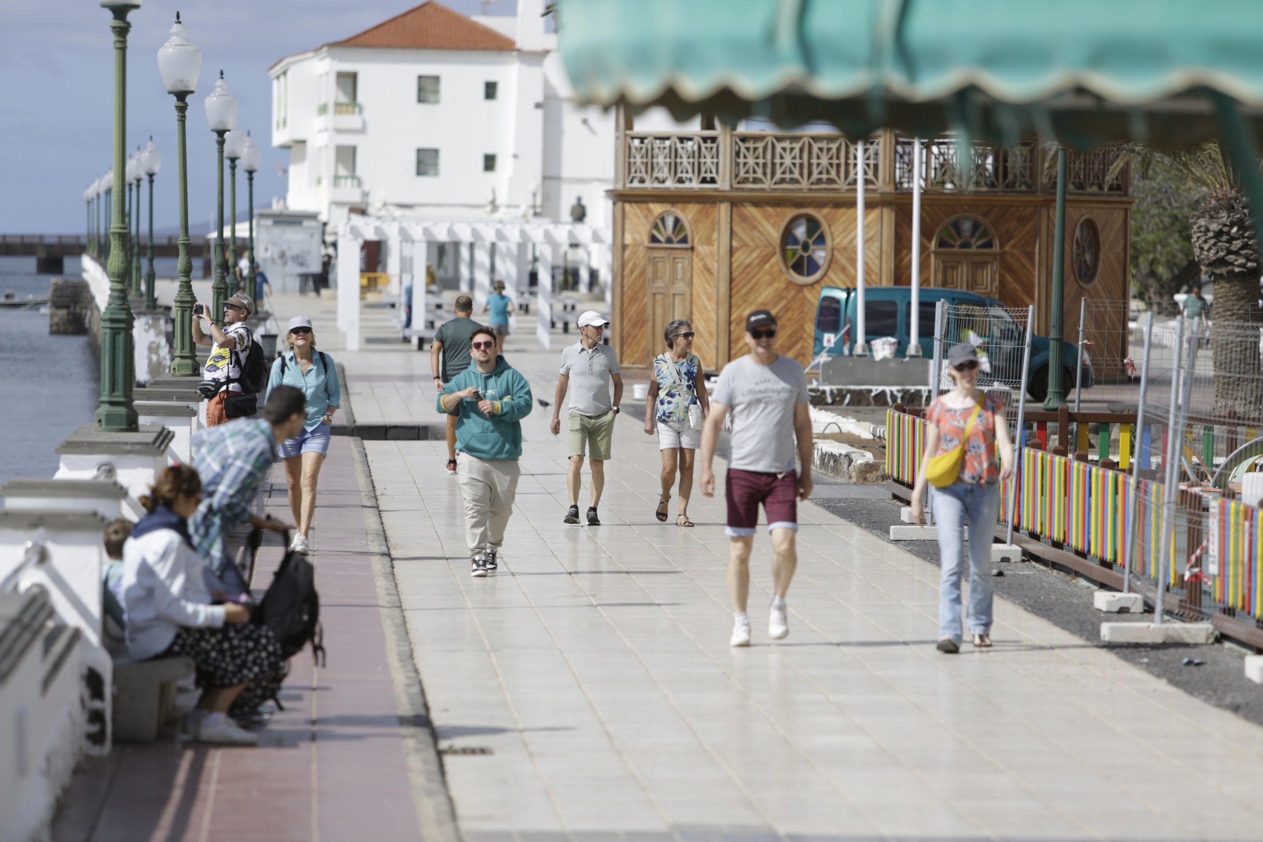 Varios turistas caminan al sol en la avenida marítima de Arrecife. Foto: Juan Mateos.