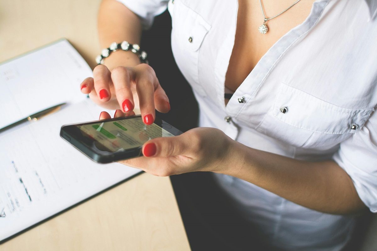 Mujer con el móvil en la mano y mensajeándose (Foto: Pexels) 