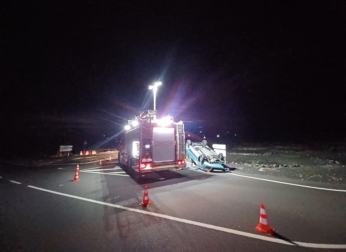 Uno de los coches volcado en la carretera tras el accidente