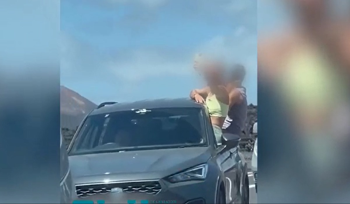 Tres jóvenes con medio cuerpo fuera del vehículo por Timanfaya