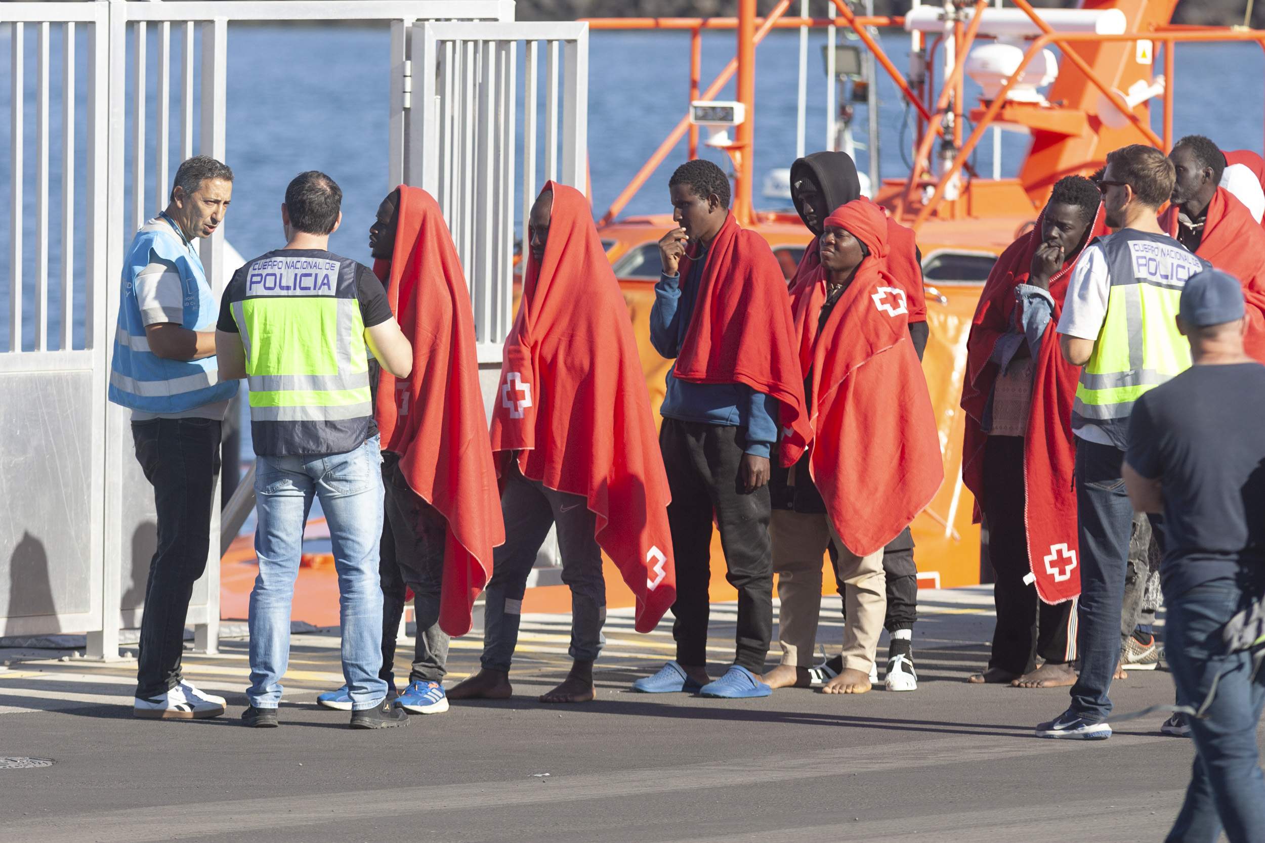 Un agente de Frontex y otro de la Policía Nacional hablan con las personas migrantes que arriban a Puerto Naos este 10 de febrero. Foto: Juan Mateos.