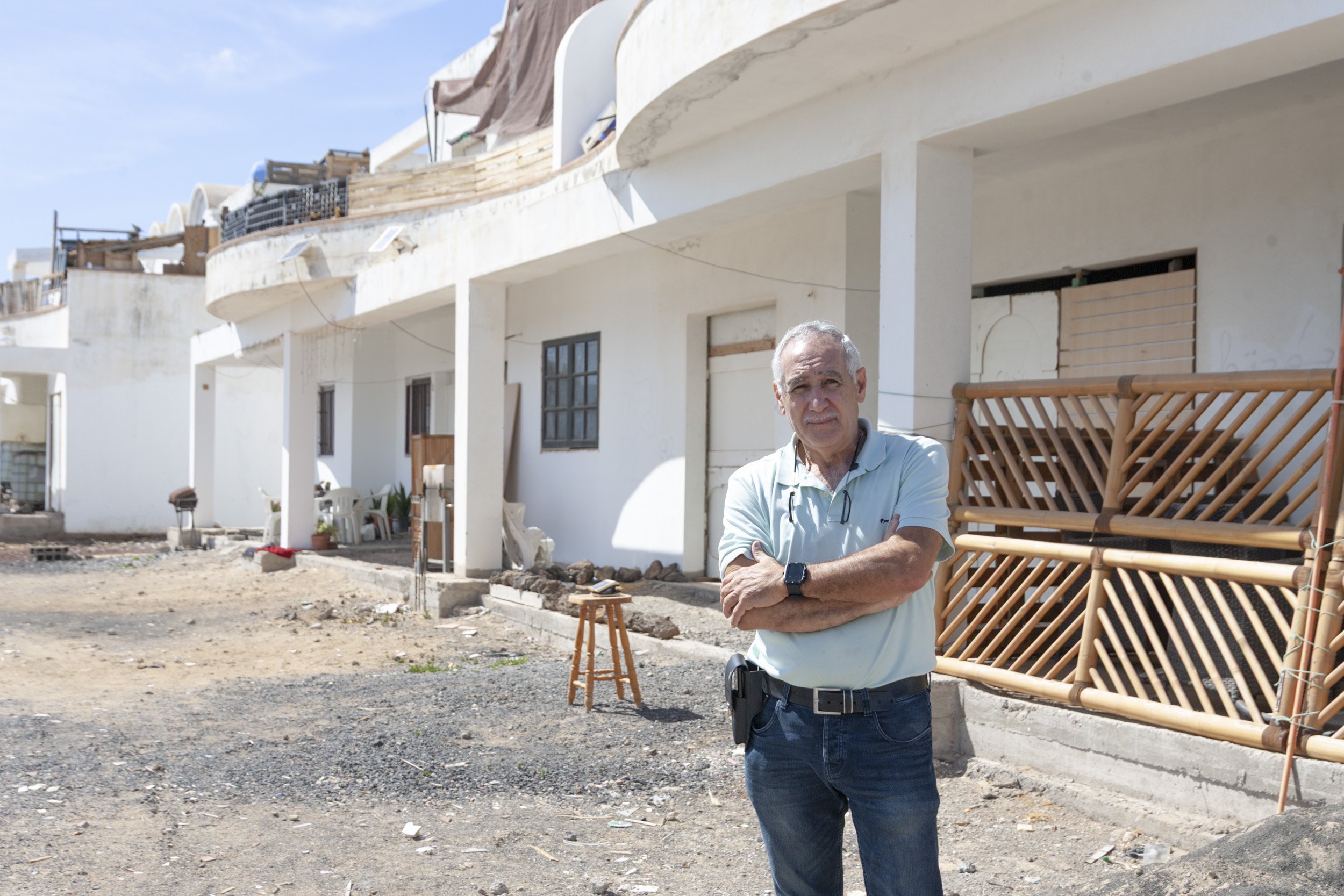 Miguel Ángel Gil junto a los esqueletos convertido en infraviviendas de Costa Teguise. Foto: Juan Mateos.
