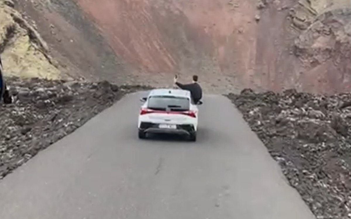 Turista con medio cuerpo fuera del coche