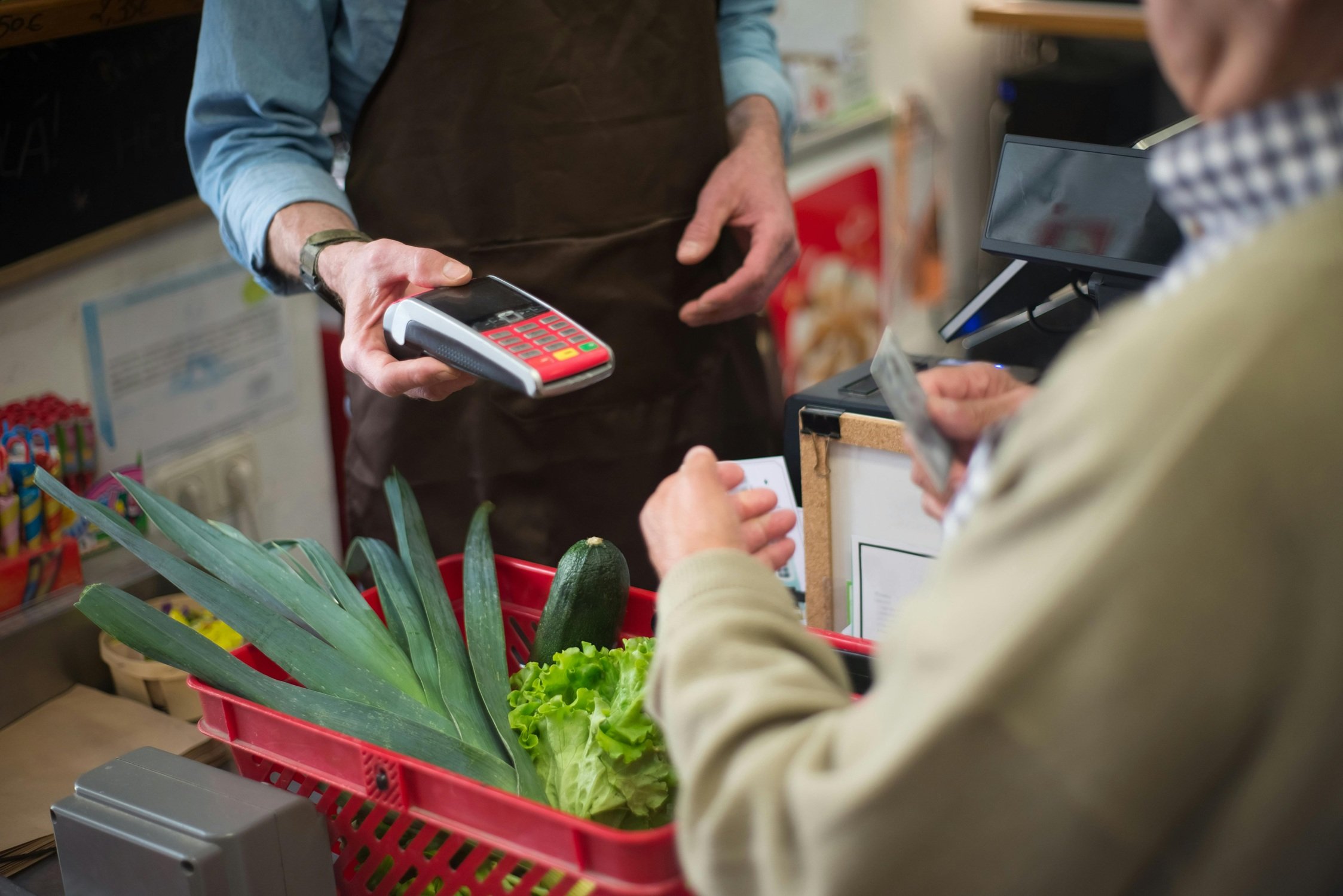 Trabajador de comercio cobrando a unos clientes.