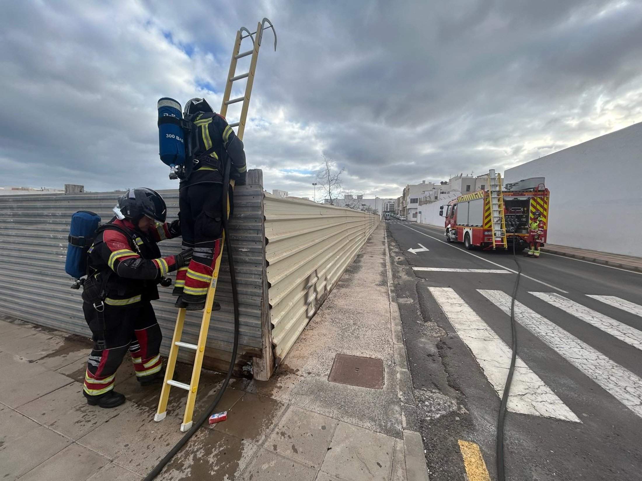 Bomberos en el solar donde se originó el incendio