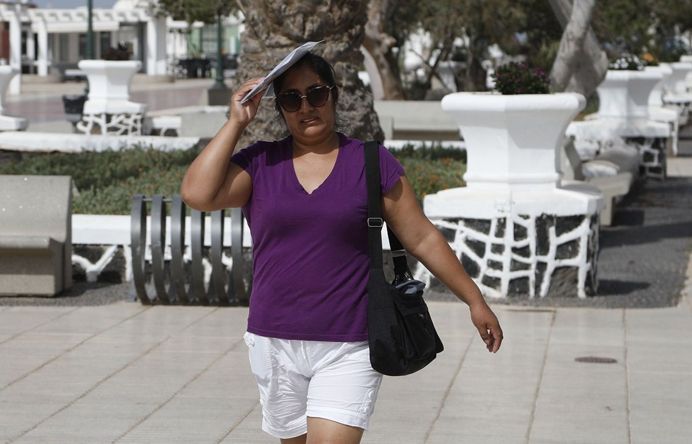 una mujer se protege del sol durante una ola de calor en arrecife en 2023cc