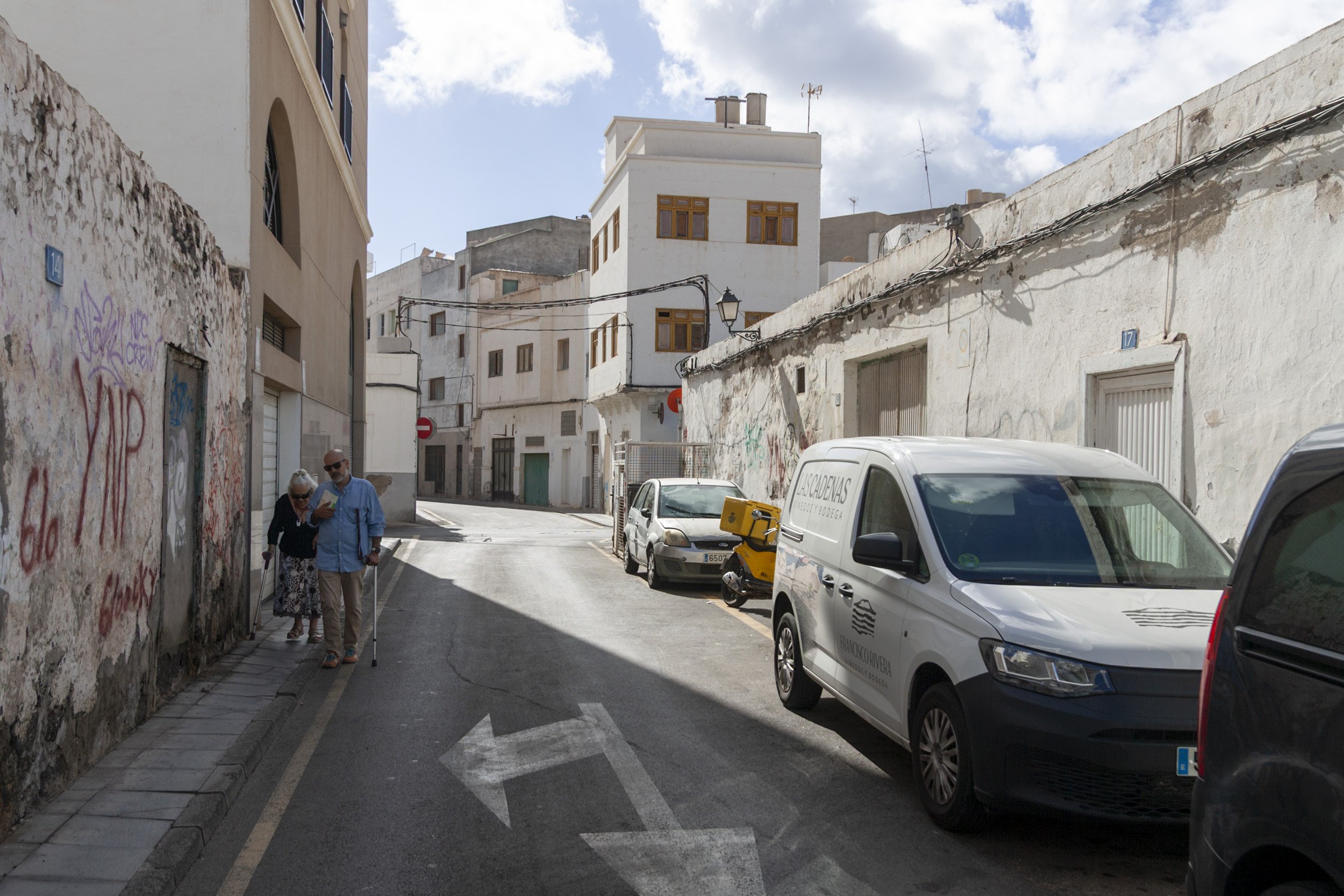 Dos personas andando por una acera estrecha de Arrecife. Foto: Juan Mateos.