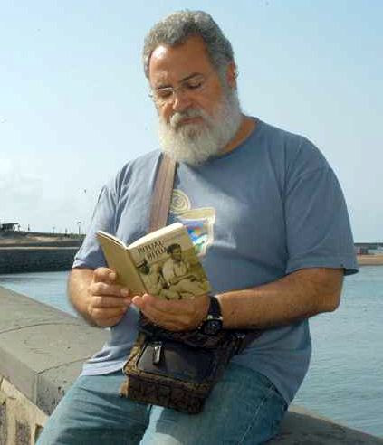 Imagen de archivo del escritor Antonio Félix Martín Hormiga, junto a uno de sus libros en la boca del muelle, en Arrecife