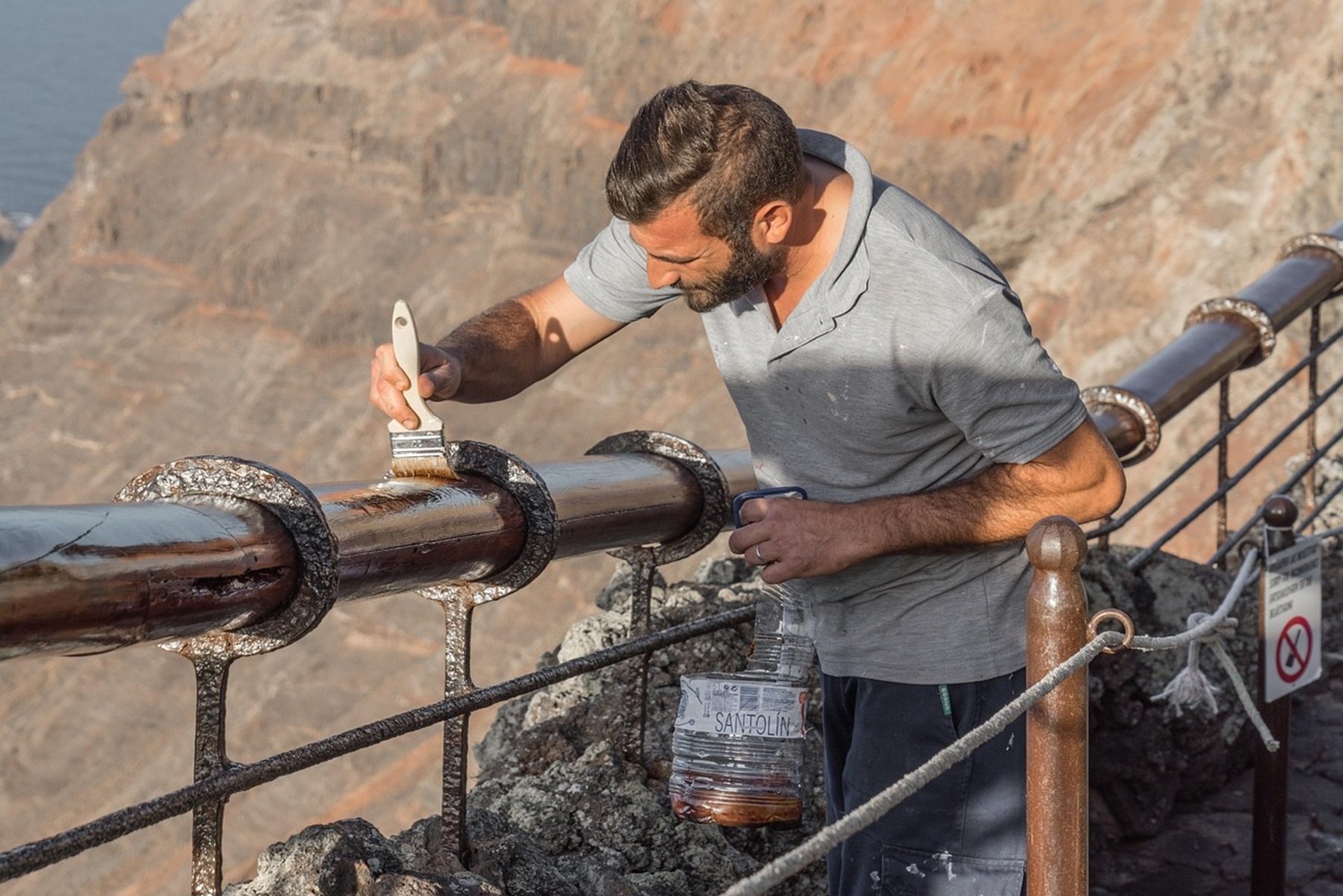 Un trabajador pintando una barandilla. I+D+i. Siniestralidad laboral.