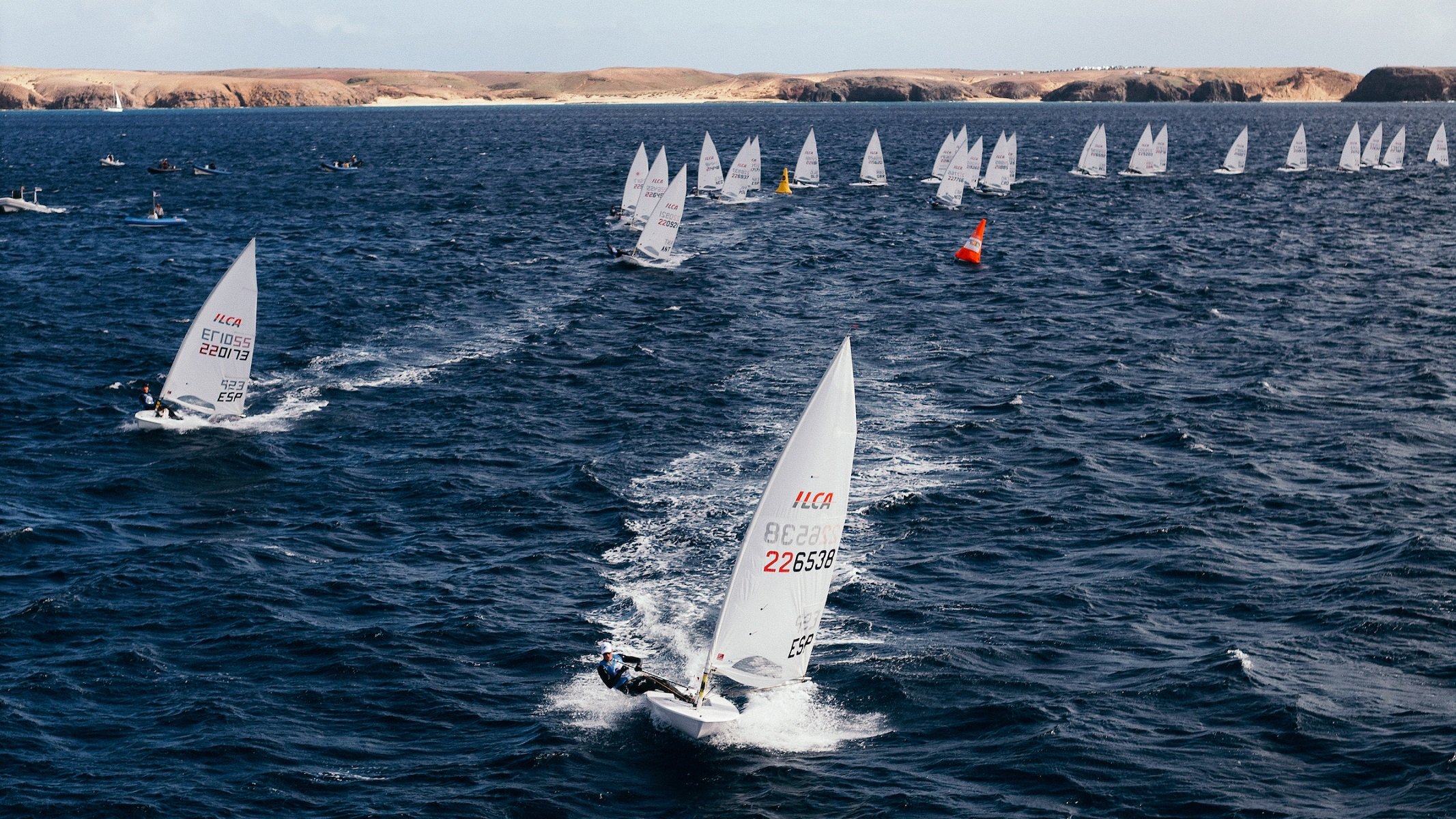Flota de ILCA 6 regateando este lunes con Lanzarote al fondo