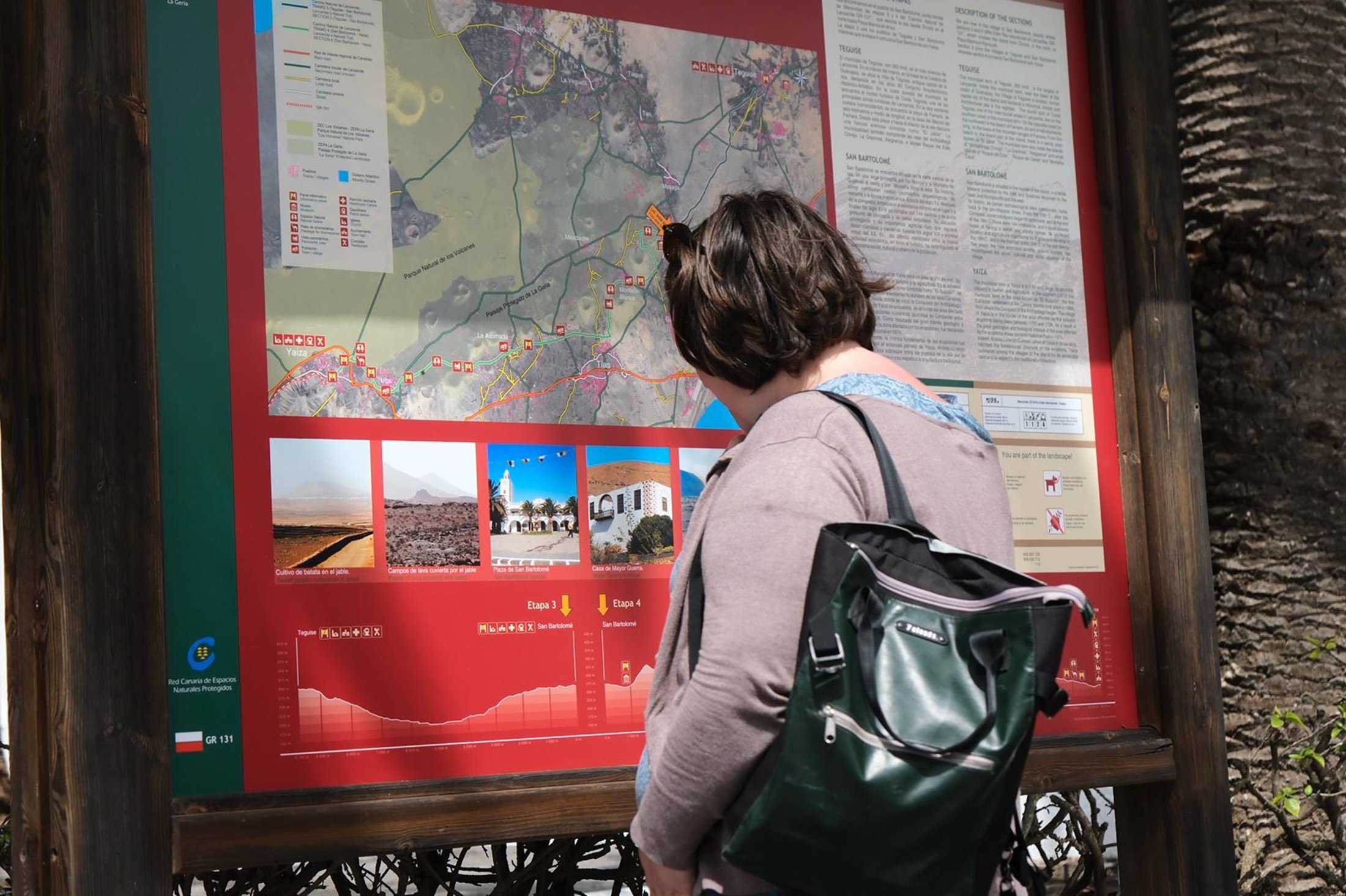 Mujer mirando el mapa de senderos de San Bartolomé