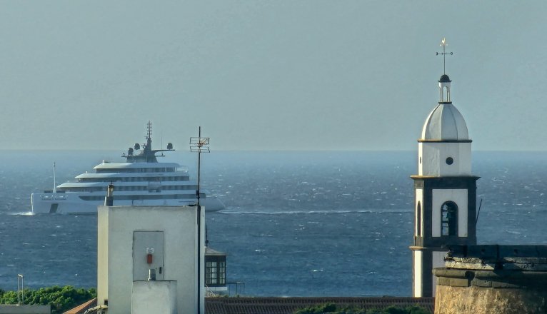 El crucero boutique Emerald Azzurra en la bahía de Arrecife para atracar en el puerto. Al fondo campanario de la iglesia de San Ginésc El crucero boutique Emerald Azzurra en la bahía de Arrecife para atracar en el puerto. Al fondo campanario de la iglesia de San Ginésc