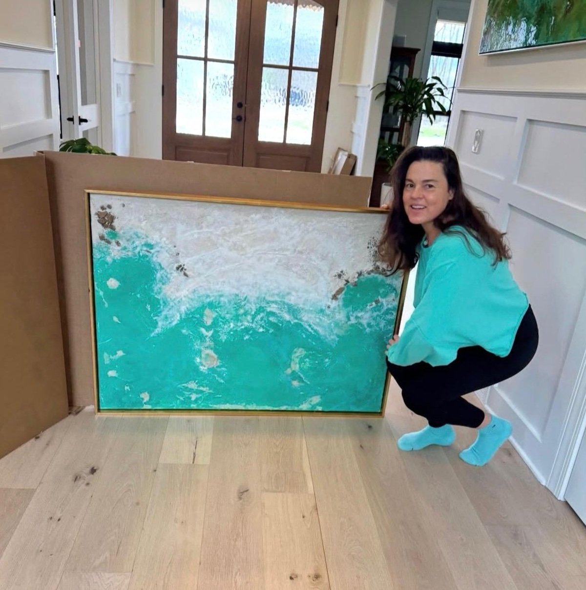 La artista Ruth María junto a uno de sus cuadros