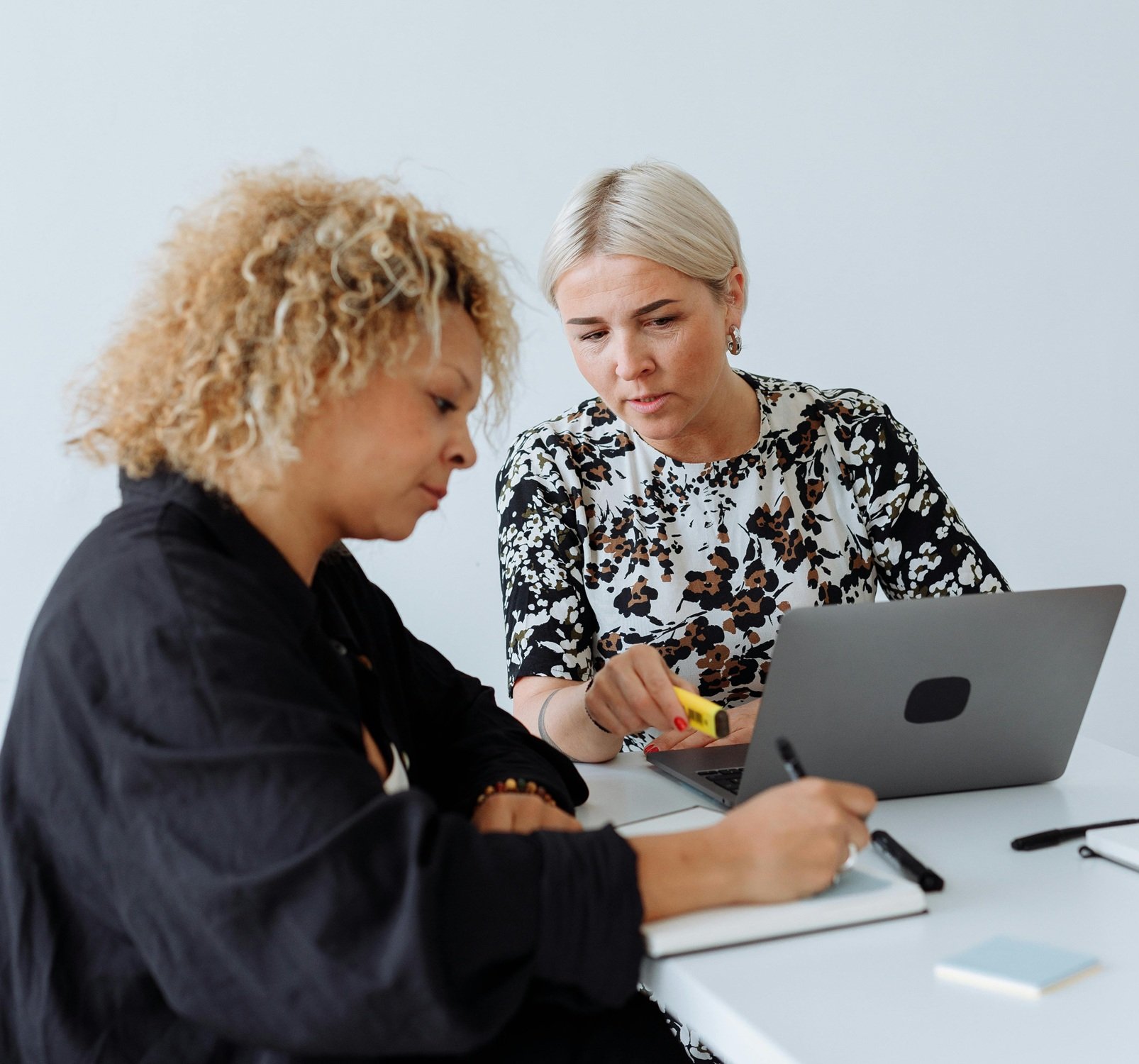 Dos trabajadoras estudian nuevas herramientas digitales. IA.