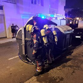 Bomberos apagando el fuego del contenedor de residuos