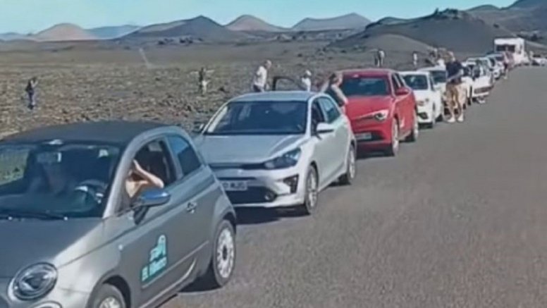 Tourists walking on the lava mountains of Timanfaya National Park