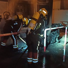 Bomberos sofocando el fuego que afectaba a la moto