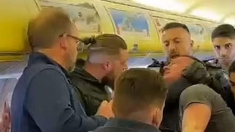 La policía agarrando a uno de los pasajeros en el avión (Foto: Daily Mail)