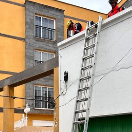 El Consorcio de Seguridad y Emergencias sujetan el cable que se había descolgado en Arrecife (CECOES)