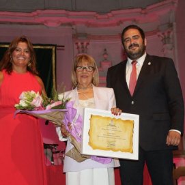 Olivia Duque y Francisco Javier Díaz entregándole un ramo de flores a la pregonera Carmelina García Barrios
