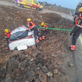 Los bomberos asegurando el vehículo a punto de caerse en Caletón Blanco
