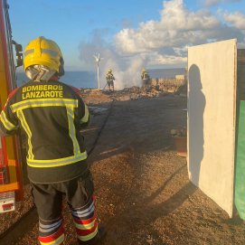 Los bomberos apagando el incendio en la casa abandonada de Playa Blanca