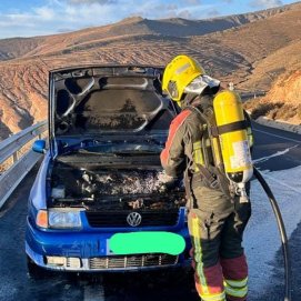 Los bomberos refrigerando el motor del vehículo en la carretera LZ-10
