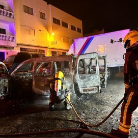 Los bomberos en la zona tratando de apagar las llamas de los vehículos
