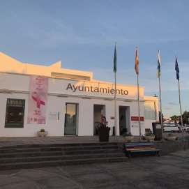 La fachada del Ayuntamiento de Tías con una lona rosa por el día mundial 