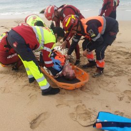 Los efectivos de emergencia y ambulancia auxiliando al accidentado en la orilla de la playa