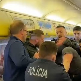 La policía agarrando a uno de los pasajeros en el avión (Foto: Daily Mail)
