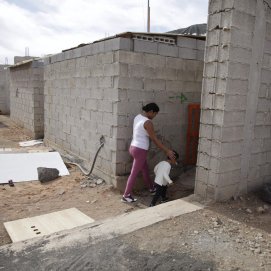 Una madre joven con su niño de dos años en una de las viviendas ocupadas de Playa Blanca. Foto: Juan Mateos.