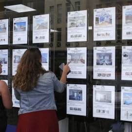 Dos jóvenes comparan opciones para adquirir una vivienda. Hipotecas.