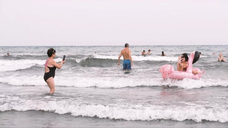 Personas en el litoral de una playa canaria.