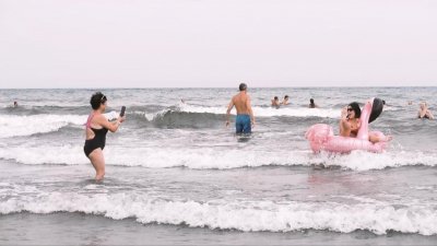 Personas en el litoral de una playa canaria. 