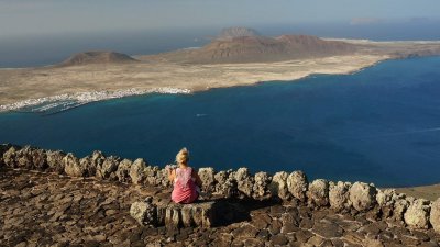 Una turista disfruta de las vistas a La Graciosa desde Lanzarote. Gasto turístico.