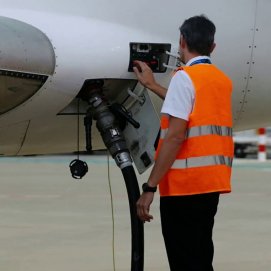 Un trabajador suministra SAF a un avión. Combustibles y sostenibilidad. Aeropuerto.