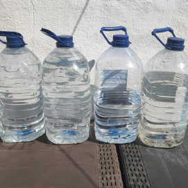 Garrafas que la mujer y su familia utiliza para poder asearse y realizar las tareas domésticas