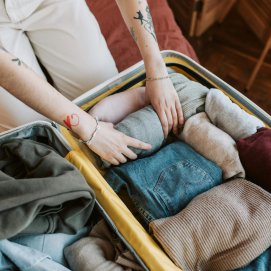 Una persona haciendo una maleta de viaje. Foto: Vlada Karpovich.