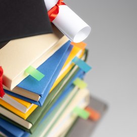 Varios libros y un diploma de la universidad.