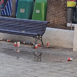 Un banco con cervezas, latas de refresco y vasos de plástico.