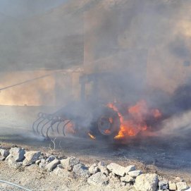 Bomberos apagando el fuego de un tractor