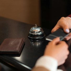 Una recepcionista de hotel atiende a un cliente. Alojamientos Turísticos.