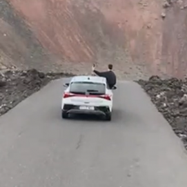 Turista con medio cuerpo fuera del coche