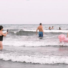 Personas en el litoral de una playa canaria. 