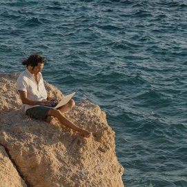 Un hombre consulta sus correos en vacaciones.