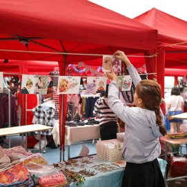 Una joven prepara su puesto de comercio. Jóvenes.