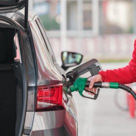 Una persona reposta combustible. Gasolina.